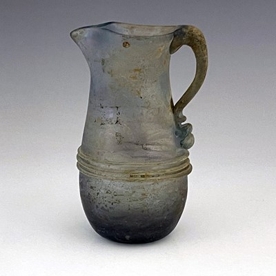 Lot 514 - A Roman glass jug, probably late Imperial,...