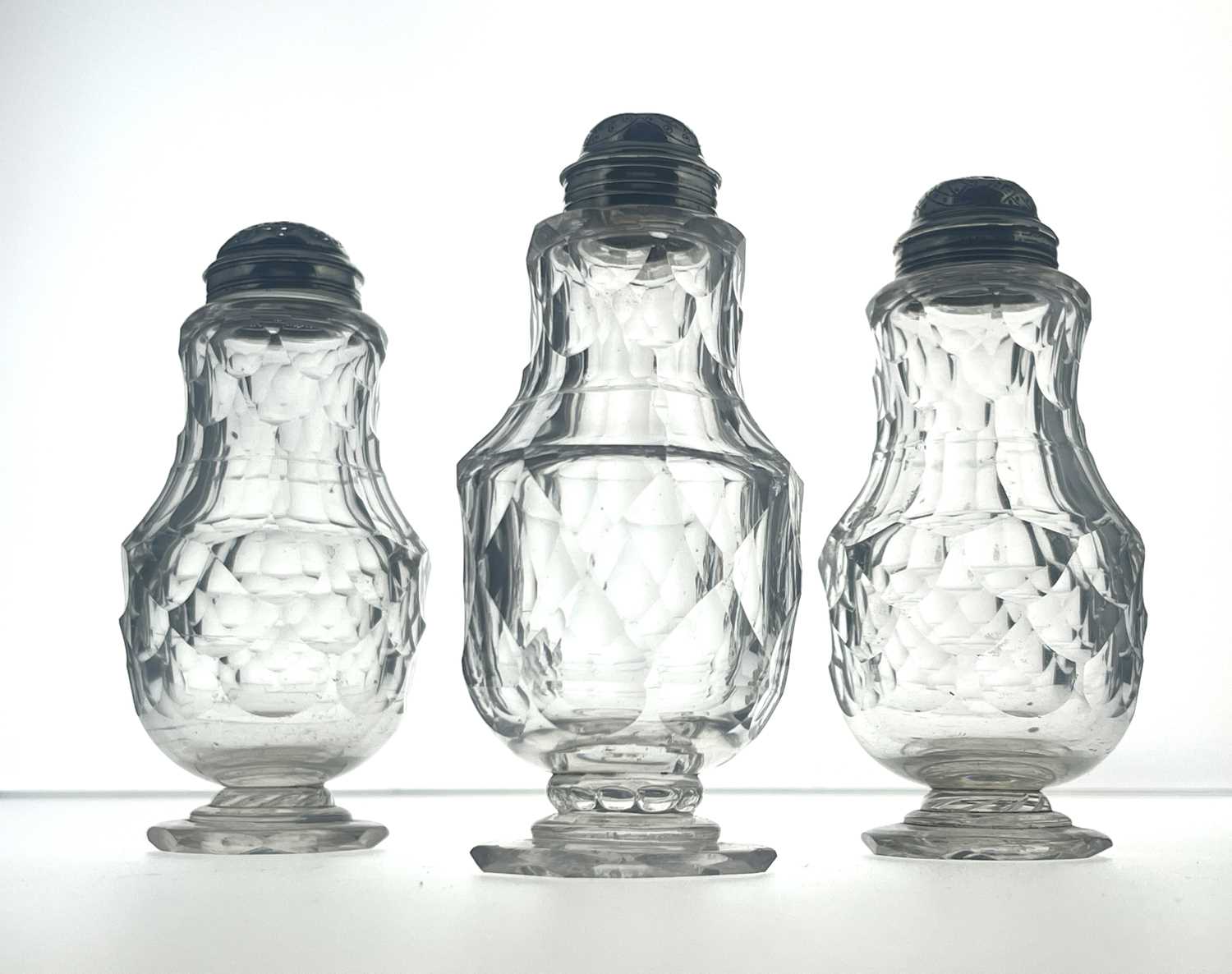 Lot 77 - Three silver mounted facet cut glass condiment shakers
