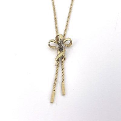 Lot 16 - A gold bow pendant necklace, set with three...