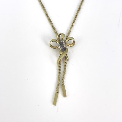 Lot 16 - A gold bow pendant necklace, set with three...