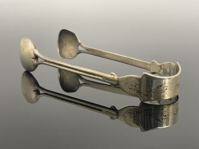 Lot 129 - A pair of Arts and Crafts silver sugar tongs,...