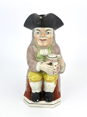 Lot 850 - A Staffordshire Toby jug, modelled with a...