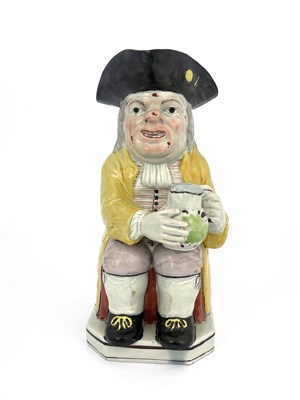 Lot 851 - A Staffordshire Toby jug, modelled with a...