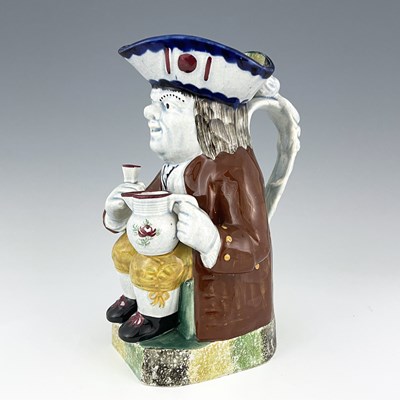 Lot 1001 - A Mexborough Toby jug, modelled holding a jug...