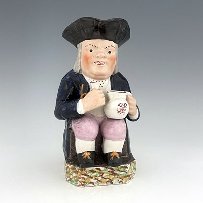 Lot 1003 - A Mexborough Toby jug, modelled holding a jug...