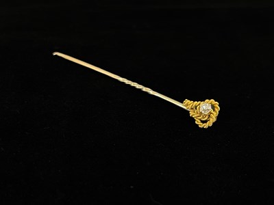 Lot 27 - A Diamond set gold stick pin, knotted...