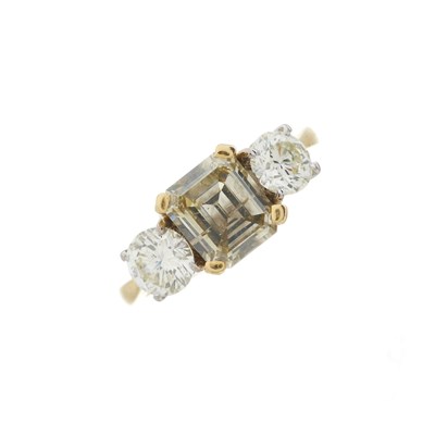 Lot 62 - An 18ct gold coloured diamond and diamond three-stone ring