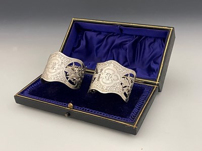 Lot 126 - A cased pair of Edwardian silver napkin rings,...