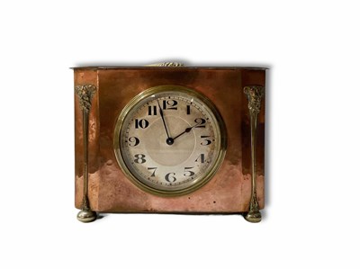 Lot 693 - An Arts and Crafts beaten copper body clock on...