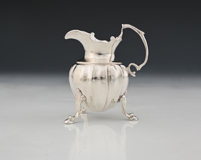 Lot 119 - A George II silver cast cream jug, the fluted...