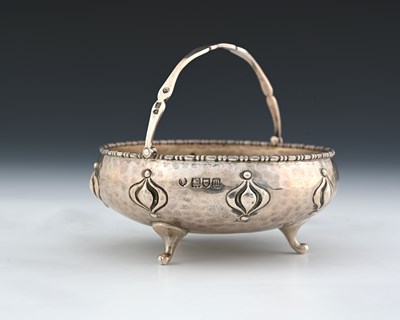 Lot 142 - An Arts and Crafts silver swing handled bowl,...