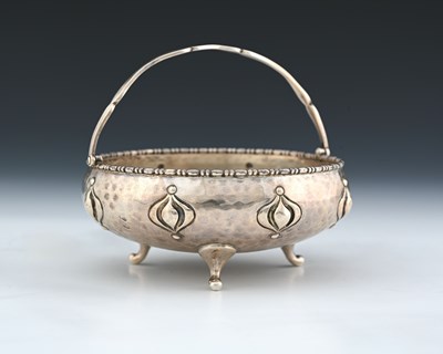 Lot 142 - An Arts and Crafts silver swing handled bowl,...