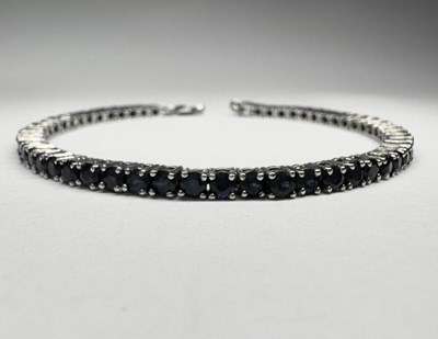 Lot 655 - A silver sapphire line bracelet