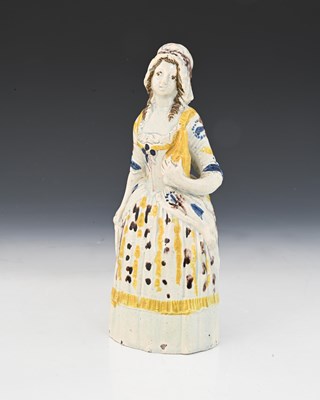 Lot 837 - A Prattware figure of a woman holding a bottle...