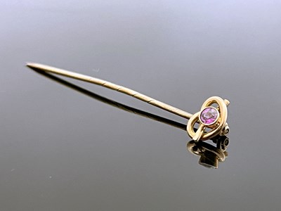 Lot 181 - A 9 carat gold and pink gem set stick pin, the...