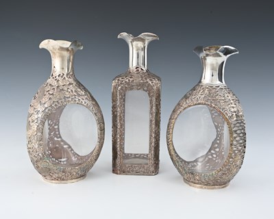 Lot 83 - China. Three Chinese silver overlay decanters,...