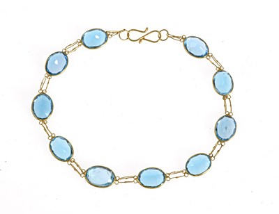 Lot 49 - A 14ct gold blue topaz line bracelet