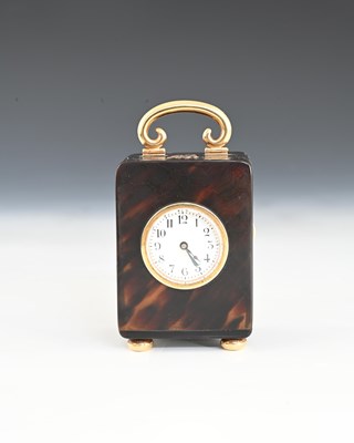 Lot 103 - A tortoiseshell travel clock with gold case components