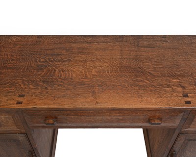 Lot 392 - A Cotswold School, Arts and Crafts oak desk,...