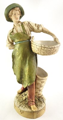 Lot 88 - A Royal Dux figure of a farm boy with basket,...