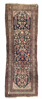 Lot 351 - A brown, red and navy runner, central...