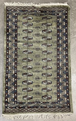 Lot 350 - A green ground wool rug with brown and blue...