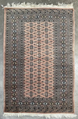 Lot 339 - A tribal/Oriental design wool rug, peach pink...