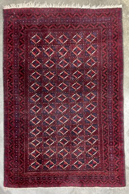 Lot 337 - A red ground Afghan Baluch-type wool rug,...