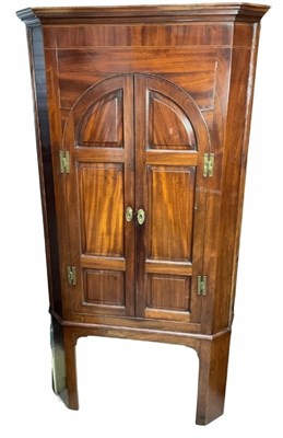 Lot 406 - A George III mahogany corner cupboard, arched...