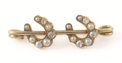 Lot 303 - An early 20th century gold pearl and diamond double horseshoe brooch