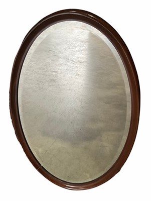 Lot 422A - A bevelled oval mirror in moulded wood frame,...