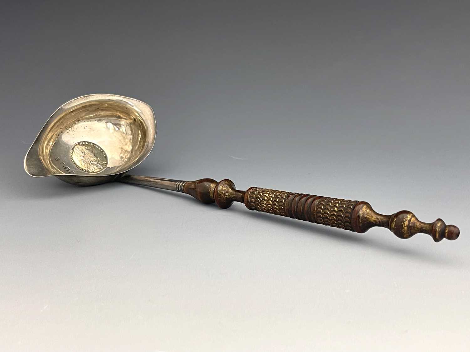 Lot 174 - A George III silver coin set ladle, Josiah...