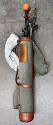 Lot 242 - A canvas and leather golf bag with clubs,...