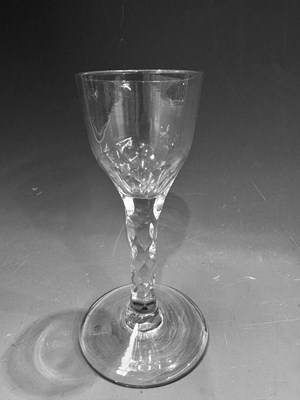 Lot 180 - An 18th century English faceted wine glass,...