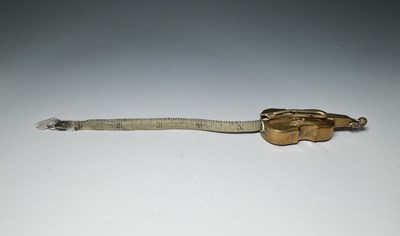 Lot 380 - A novelty brass tape measure, in the form of a...