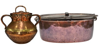 Lot 215 - A copper twin handled pot with lid, possibly...