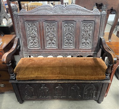 Lot 586 - A profusely carved oak hall settle or monks...