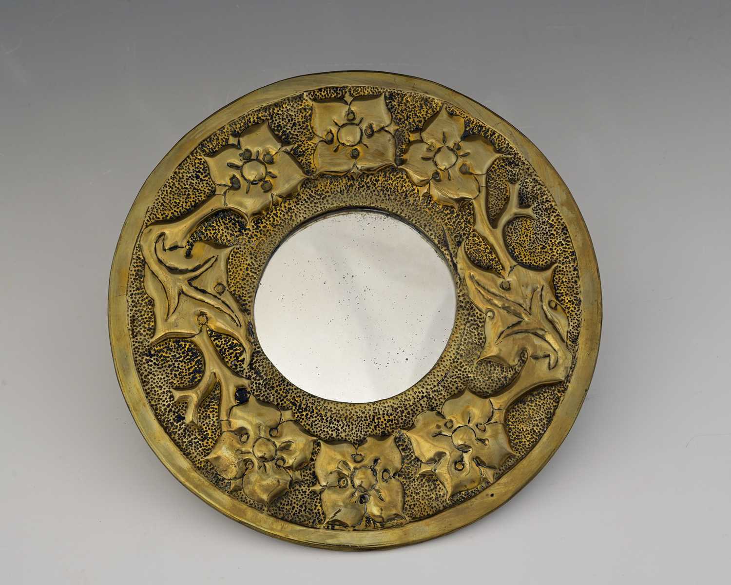 Lot 101 - An Arts and Crafts brass mirror, circular form,...