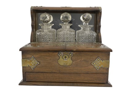 Lot 155 - An Edwardian oak tantalus, fretwork Gothic...