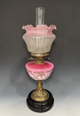 Lot 661 - A Victorian brass oil lamp, the pink milk...