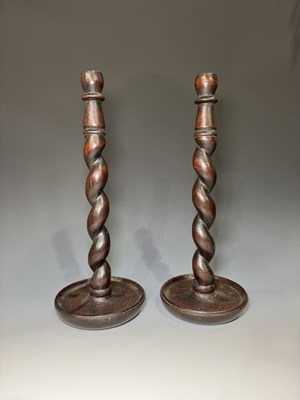 Lot 220 - A pair of stained oak candlesticks, carved...