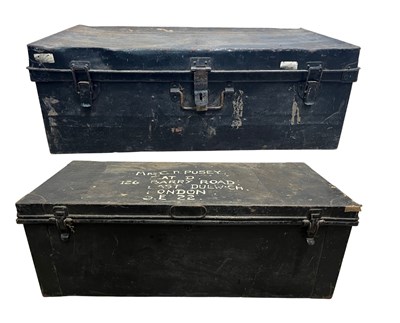 Lot 519 - Two black metal travel trunks, the largest...