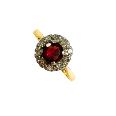 Lot 411 - An 18ct gold and platinum, garnet and diamond cluster ring