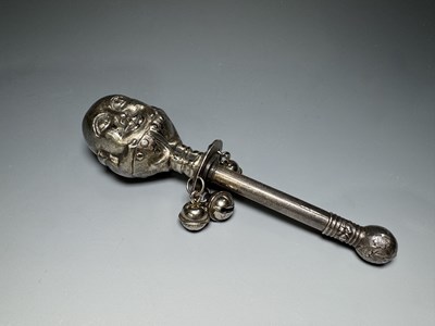 Lot 246 - A white metal rattle with three bells, cast in...