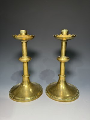 Lot 231 - A pair of Arts and Crafts brass candlesticks...