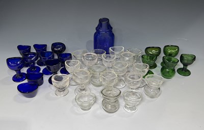 Lot 40 - A large collection of glass eye baths,...