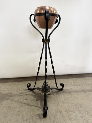Lot 545 - A black painted wrought iron tripod plant...