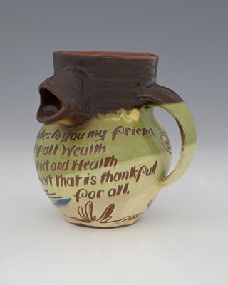 Lot 557 - C H Brannam, an art pottery fish motto jug,...