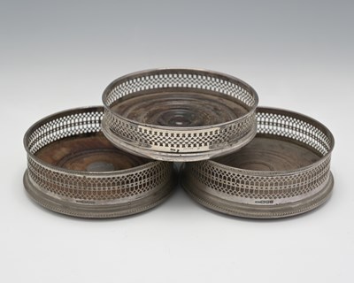 Lot 86 - Three twentieth-century silver bottle coasters,...