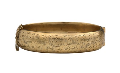 Lot 25 - A 9ct gold engraved hinged bangle bracelet